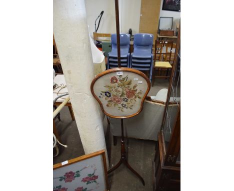 A pole screen with floral tapestry panel