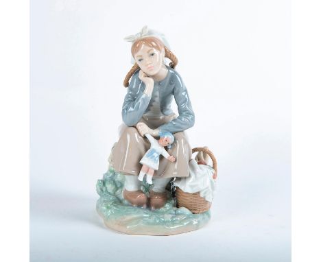 Glossy porcelain figurine of a girl holding her doll and staring off into the distance. Lladro backstamp. Includes original b