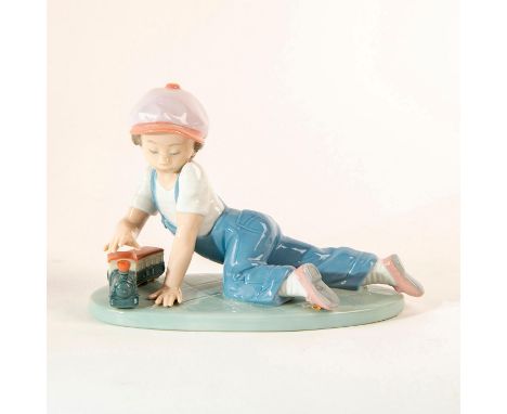 A boy sits playing with his toy train. No box Issued: 1993Dimensions: 5"H x 7.5"WManufacturer: LladroCountry of Origin: Spain