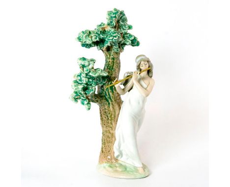 Glazed; Woman playing flute next to lush tree. With original box. Lladro backstamp. Artist: Antonio RamosIssued: 1990-1996Dim