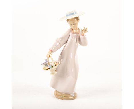 Glossy porcelain figurine of a girl in a long dress and sun hat carrying a basket of flowers. Lladro backstamp. Artist: Salva