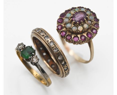 Three rings including a 9ct ruby and opal cluster ring, three stone emerald and diamond ring (not marked) and eternity full b