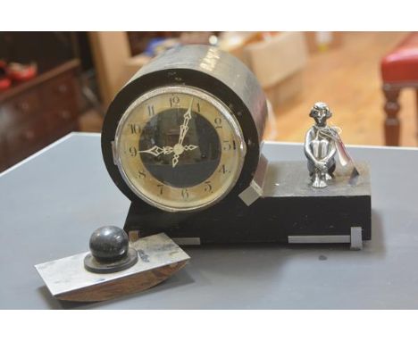An ebonised wooden mantel clock in the Art Deco taste, c. 1930, the drum head enclosing a chapter ring with Arabic numerals, 