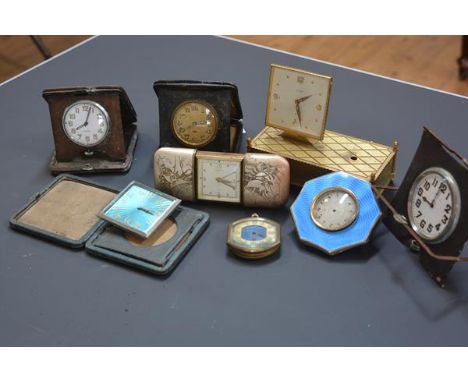 A group of seven vintage travel clocks, some with engine-turned enamel cases (losses); together with a vintage brass-cased de