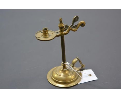 A 19th century brass taper holder/snuffer, with urn finial, on a circular base. 14cm