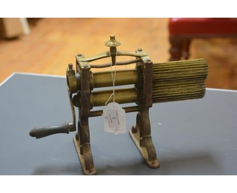 A brass table top crimping machine, second quarter 19th century, with urn finial. 25cm