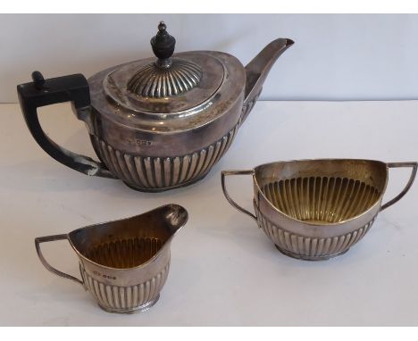 An early-20th century bachelor's hallmarked silver three-piece tea service comprising a bachelor's teapot, two-handled sugar 