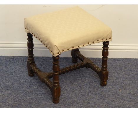 A late-17th century oak stool, the later upholstered top above four turned and block supports united by a bobbin-turned 'H' f