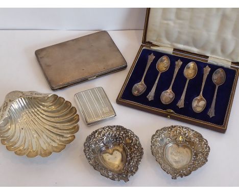 A silver group to include a set of six hallmarked tea spoons, a heavy engine-turned silver cigarette case, one further smalle