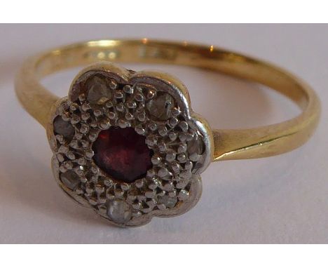 A lady's 18-carat yellow-gold dress ring centrally set with a small red stone (probably ruby) and surrounded by smaller white