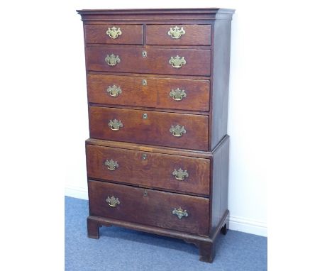 A George III period oak chest on chest, the outset cornice above an arrangement of two half-width drawers and five full-width