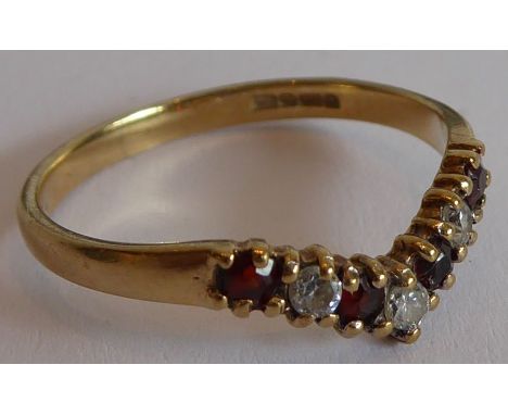 A lady's 9-carat yellow-gold ring centrally set with four small red stones and three further small white stones in a 'V' desi