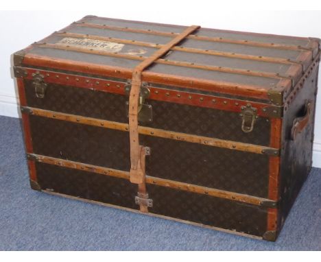 A large early 20th century wooden and leather-bound travelling trunk by Louis Vuitton; the top back and front riveted with na