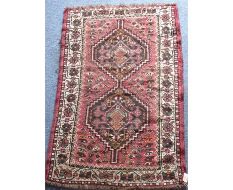 A hand-knotted Persian Hamadan rug, two darker hexagonal 'guls' against a red ground (164cm x 108cm)This trunk has come priva