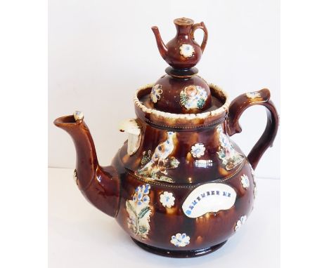 A large 19th century Barge ware pottery teapot decorated in relief with floral sprays, flower heads, exotic birds and surmoun