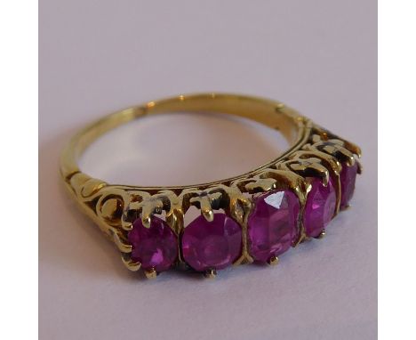 An old yellow-gold ring set with five rubies in a carved claw setting Approx dimensions are:-              approx. 5mm height