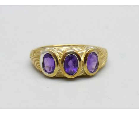 A silver gilt, amethyst three stone ring, T/U 