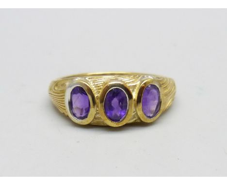 A silver gilt, amethyst three stone ring, T/U 