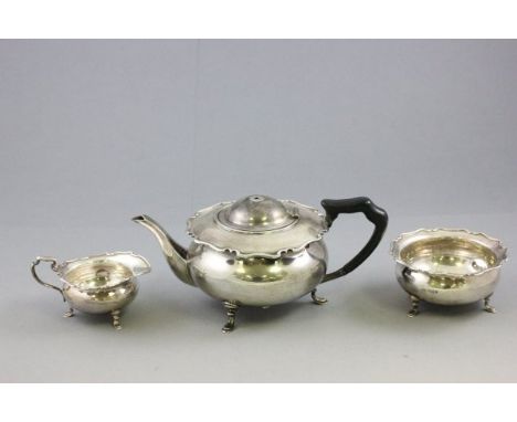 Silver Three Piece Tea Service of squat form with scalloped edge, the teapot with ebony handle and finial, Sheffield 1911, He