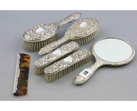 Six Piece Silver Dressing Table Set comprising Mirror, Four Brushes and a Comb, each with embossed bird and scroll decoration