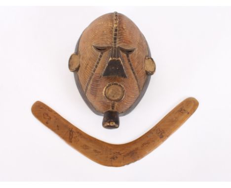 A vintage carved African tribal art mask; together with an antique Australian Aboriginal boomerang with poker work decoration