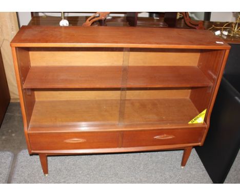 A teak G plan design bookcase, the adjustable shelf enclosed by glazed sliding doors with drawers below, 109cms wide