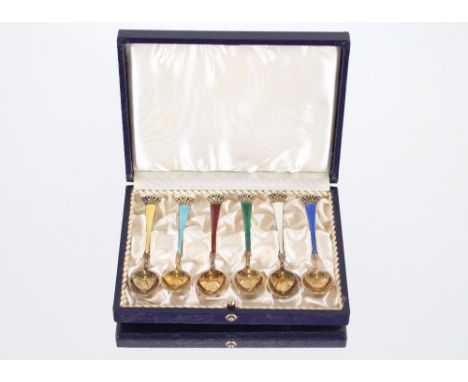 A cased set of six silver gilt and variously coloured enamel coffee spoons, with pierced coronet terminals