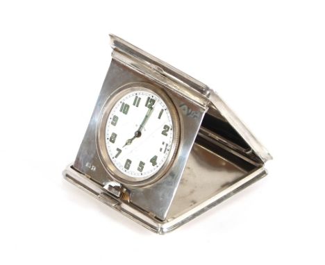 A silver cased travelling timepiece, with white enamel dial, green Arabic numerals, contained within a fitted square hinged c