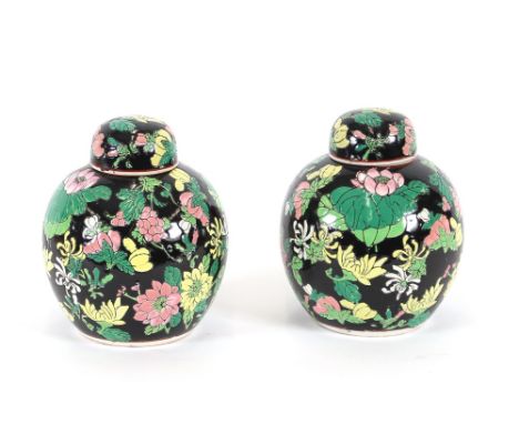A pair of oriental ginger jars, profusely decorated coloured enamel flowers and fruit