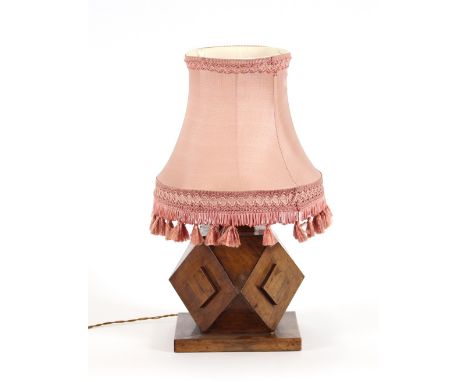 A hardwood table lamp, of stylised design with tasseled pink shade