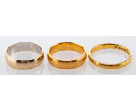 A 22ct gold wedding band, stamped 22 with full London hallmarks for 1954, ring size O, 3.9g; a further 22ct gold wedding band