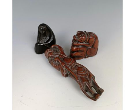 A carved wooden netsuke, in the form of a man, 9 cm, another in the form of a woman, 4 cm, and another in the form of a dog (