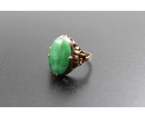 A 14k gold ring, decorative shoulders, inset an oval jade cabochon, gross weight; 4.5g, ring size: K