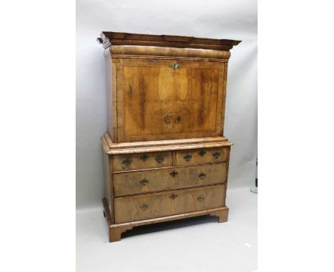 An early to mid 18th century walnut escritoire having moulded cornice, over concealed cushion long drawer, the fall reveals, 