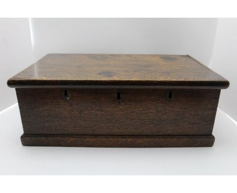 A 19th century oak box with hinged lid, the front panel reveals three lock holes (no locks), 46cm x 27.6cm x 16.5cm high