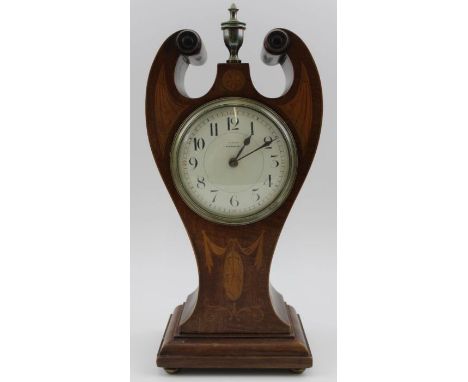 An Art Nouveau form mahogany cased mantel timepiece, sweeping swan neck form with brass urn finial, inlaid decoration raised 