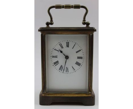 A French brass cased carriage clock, hinged bale handle, white enamel dial with Roman numerals, the case 11cm high