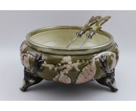 A Wedgwood majolica salad bowl, moulded with three stag mask supports, having a plated rim, complete with a pair of salad ser
