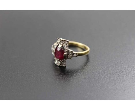 An 18ct gold band, set diamonds in an Art Deco mount, presenting a central facet cut ruby, ring size: M1/2