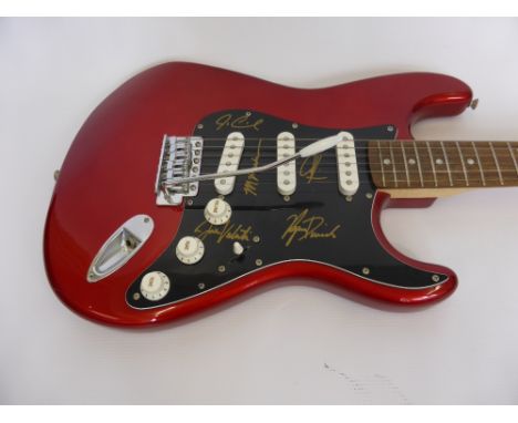 A Fender Stratocaster Squier Electric Guitar, hand signed by Eric Clapton, Ginger Baker and three others.