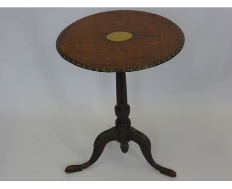 An Antique Oak Wine Table, the table on turned column with carved tripod base, the top with decorative edging has a brass ins