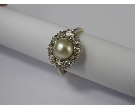 A Lady's 18ct Yellow and White Gold Diamond and Pearl Ring. The ring set with ten graduated diamonds surrounding a central pe