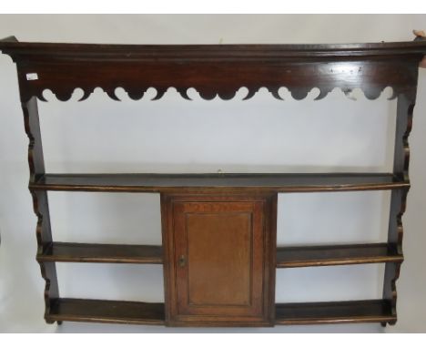 An Antique Oak Three Shelf Dresser Top, having a decorative wave form frieze with central spice cupboard approx 150 x 20 x 12