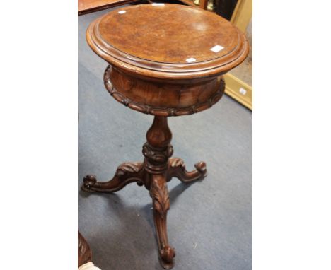 A VICTORIAN WALNUT TEAPOY of waisted form on carved tripod base, the circular top lifting to reveal a fitted interior with tw