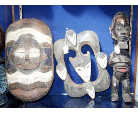 A COLLECTION OF TRIBAL ART, A Nigerian fist shield, a "Kwell" mask and a "Fang" study of a man with cowrie shells (3)