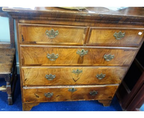 A GEORGE I WALNUT AND CROSSBANDED CHEST OF DRAWERS with deep moulded cornice on later bracket feet (the top of a chest-on-che