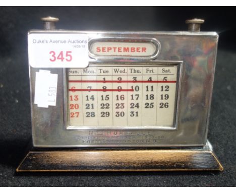 A SILVER AND WOODEN DESK CALENDAR, inscribed 'Mrs Huxtable enrolling Member 1920-30 from Fordington M U' 