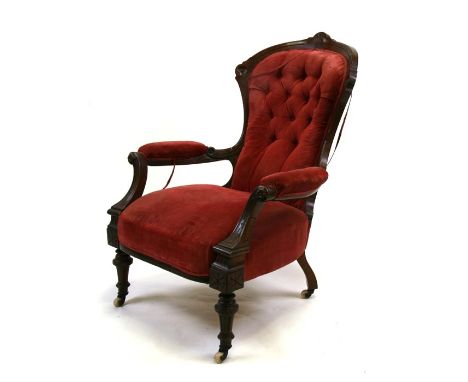 A Victorian button back upholstered walnut armchair on turned front supports.