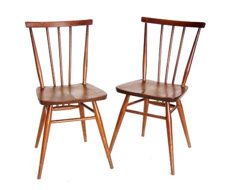 A pair of mid century Ercol stick back kitchen chairs with solid seats.