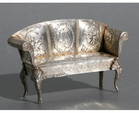 A Victorian novelty miniature silver sofa with repousse decoration, John George Smith, London 1899, weight 40g, 7.5cms (3ins)